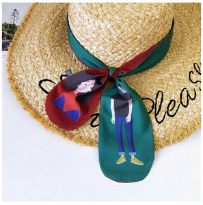 Detail showing the woven texture of straw hat and cartoon printed silk ribbon accessory