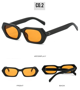 Detail of black hexagonal sunglasses with orange lenses and metal rivet accents