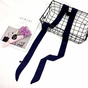 Detail of dark blue skinny silk scarf with neat stitching and glossy satin texture