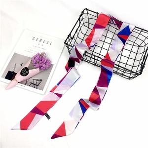 Detail view of long skinny scarf with colorful geometric patterns on white background