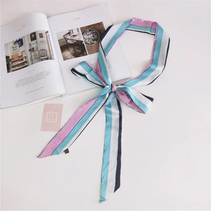 Close-up of a colorful striped skinny scarf draped over a fashion magazine