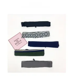 Detail of five assorted satin skinny scarves in navy, floral, and striped patterns