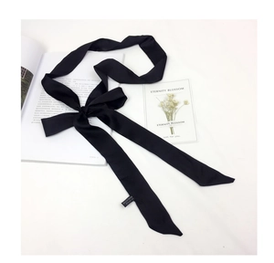 Detail of elegant black satin scarf tied in a bow with sharp diagonal cut ends
