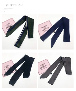 Macro display of narrow silk-like scarves in forest green, navy blue, and black tones