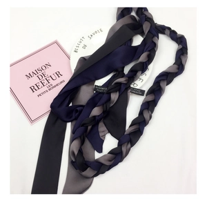 Detailed macro view of smooth polyester texture and woven labels on narrow scarves