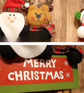 Detail of Christmas fabric ornaments with 3D Santa and Merry Christmas wooden plaque