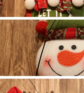 Detail of Let It Snow wooden sign with plush Santa and Snowman Christmas decorations