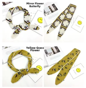 Nahaufnahme eleganter Seidenschals mit Blumen und Streifen in Gelb und Beige