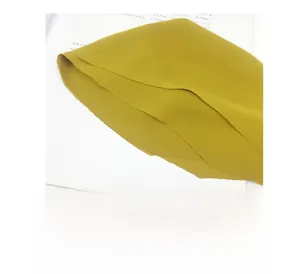 Detail of high-temperature laser-cut edges on a yellow chiffon scarf with no hemming
