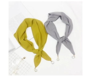 Detail of chiffon scarves in yellow and grey with gold tips and pearl charms