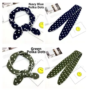 Detail von schmalen Seidenschals mit navy-grünen Polka-Dots und feiner Textur