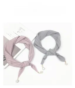 Detail of striped silk scarves with decorative pearl and crystal ball pendants