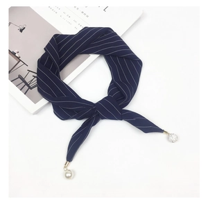Detail of navy striped silk scarf showing pearl and glitter ball pendant accessories