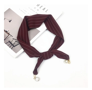 Detail of burgundy striped silk scarf with elegant pearl and rhinestone sphere pendants