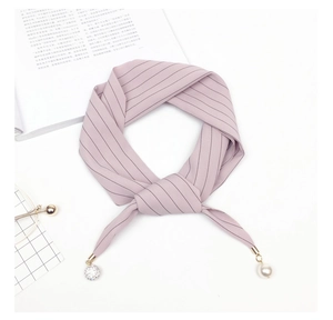 Close-up of pink striped silk scarf featuring elegant pearl and crystal ball charms