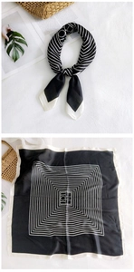 Detail of elegant black and white silk square scarf with geometric patterns on fabric