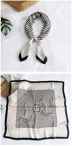 Detail of elegant black and white silk scarf featuring geometric lines and love patterns