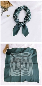 Macro view of dark green satin square scarf with geometric pattern and silk texture