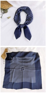 Detailed view of dark blue silk square scarf with white geometric lines and satin texture