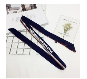Detail of navy skinny scarf featuring rhinestone accents and red-white striped edges