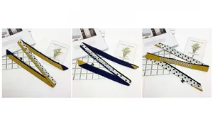 Detail of skinny silk scarf with polka dots and rhinestones in yellow and navy blue
