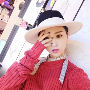 Asian model wearing a black and white geometric pattern skinny scarf with a red sweater