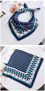 Détail d'un foulard en soie bleu marine avec des rayures et des pois rouges et blancs