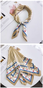 Détail d'un foulard en soie kaki à rayures avec bordures bleues et motifs à pois