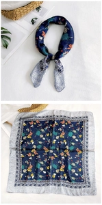 Detailed view of square silk scarf featuring blue floral patterns and classical borders