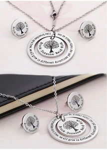 Detailed view of silver tree of life pendants and earrings with custom name engravings
