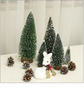 Close-up of mini cedar Christmas trees with snow, plush reindeer, and pine cones decor