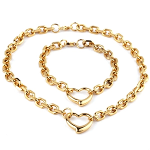 Close-up of golden chunky chain jewelry set with heart pendants including necklace and bracelet