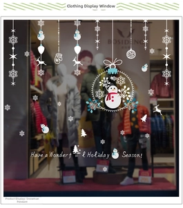 Detail of Christmas snowman window stickers with snowflakes on glass storefront