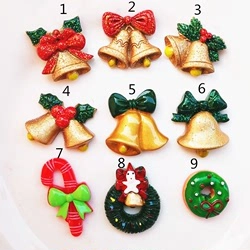 Flat lay of 9 assorted Christmas resin charms including bells and gingerbread man on a white plate