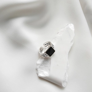 Macro shot of S925 silver ring featuring a square black drip stone and chain link band