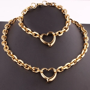 Macro shot of gold heart chain necklace and bracelet set displayed on a black bust