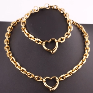 Golden stainless steel jewelry set featuring a chunky link necklace and heart toggle bracelet