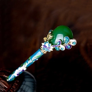 Macro detail of Chinese hair pin with green teardrop stone and blue enamel floral patterns