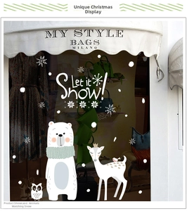 Detail of Christmas window decals featuring polar bears, deer and snow on store glass