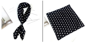 Vue détaillée d'un foulard en satin noir à pois blancs noué et posé à plat