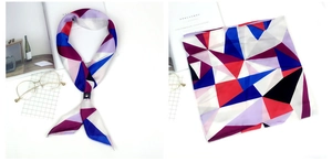 Détail macro d'un foulard en satin géométrique abstrait avec motifs rouges et boucle en cuir