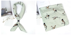 Détail d'un ensemble de foulards en satin vert clair avec motif de grue et rayures fines