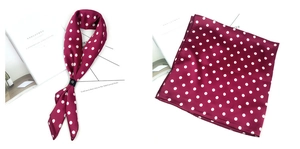 Petit foulard en satin rouge foncé à pois blancs noué et plié pour un look vintage