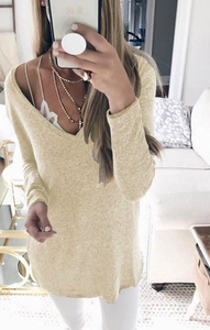 Detail view of a V-neck knit sweater in light beige with fine ribbed texture and long sleeves