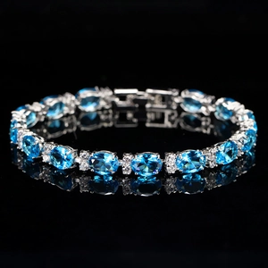 Macro shot of silver bracelet featuring oval blue gemstones and sparkling zircon accents