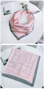 Detail of pink silk scarf featuring grey geometric spiral patterns and fine rolled edges