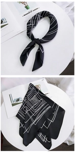 Detail of minimalist silk scarf with black geometric lines and silk texture on decor
