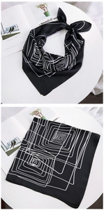 Detailed view of black silk scarf with white geometric lines and elegant satin finish