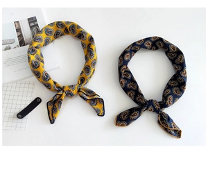 Close-up of yellow and navy linen-blend scarves with elegant paisley floral patterns