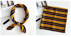 Macro shot of striped square linen silk scarf with glossy yellow and navy patterns